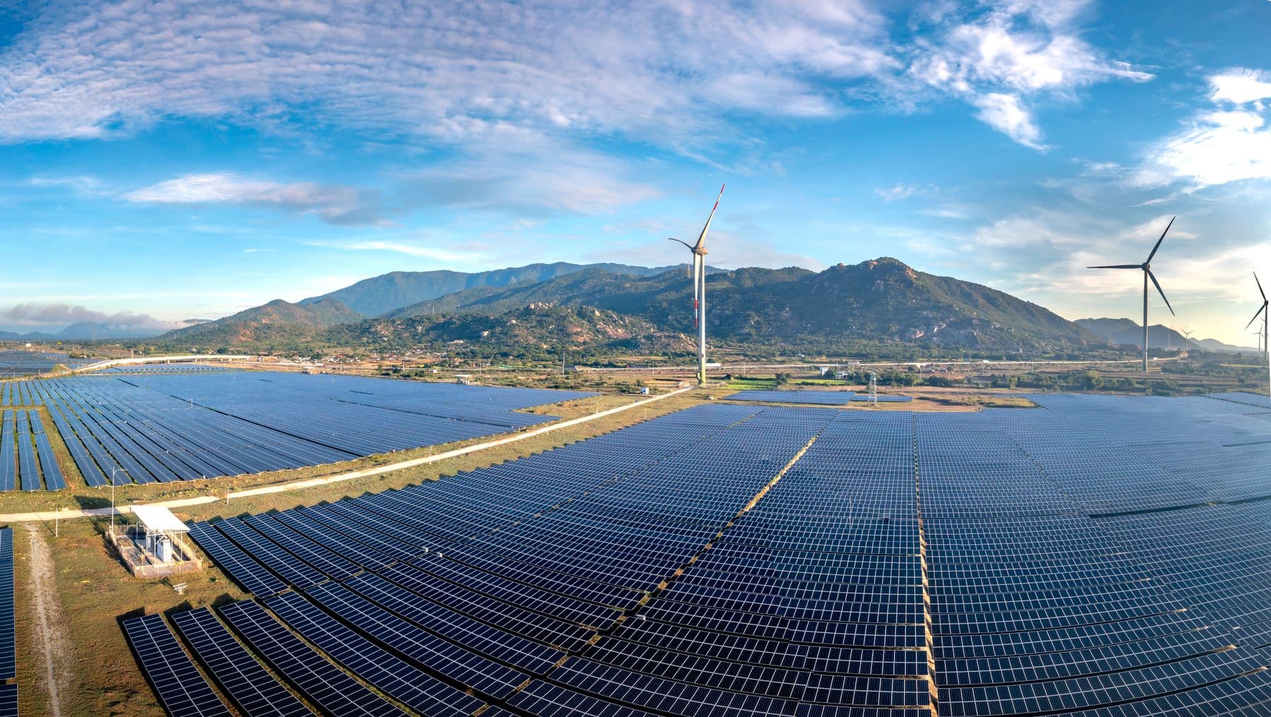 Solar panel arrays and wind turbines across a renewable energy farm